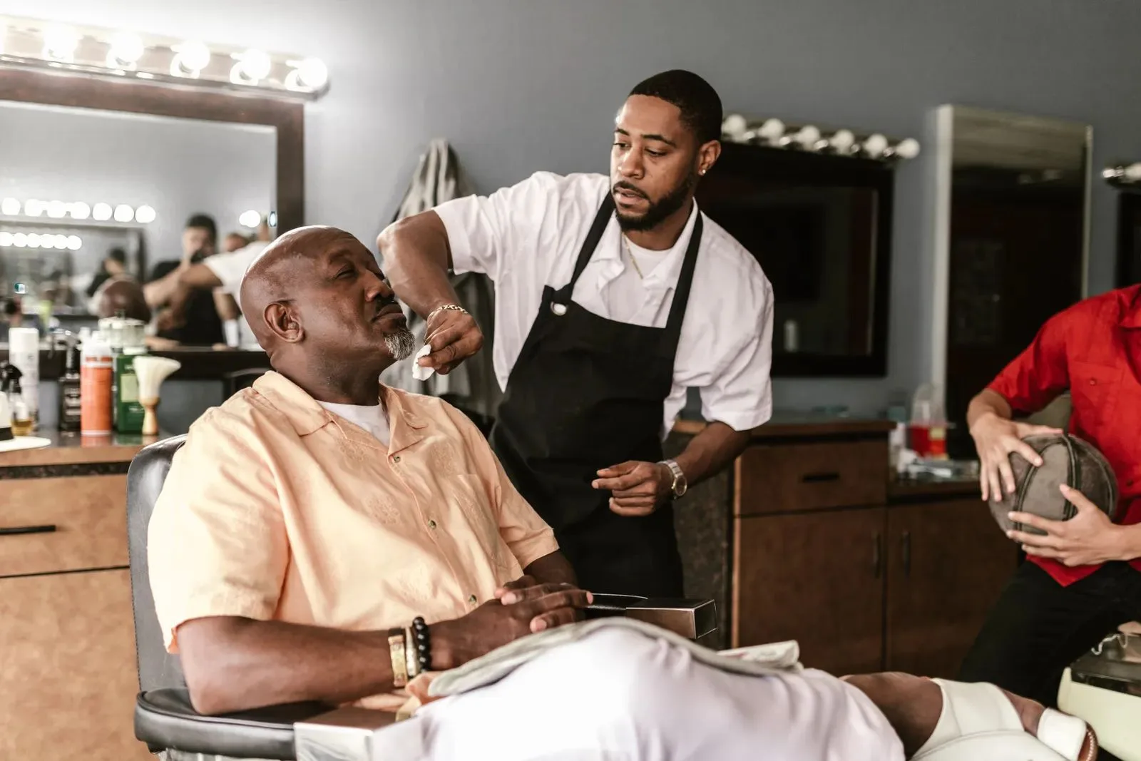 A barber finishing up with a client in the chair