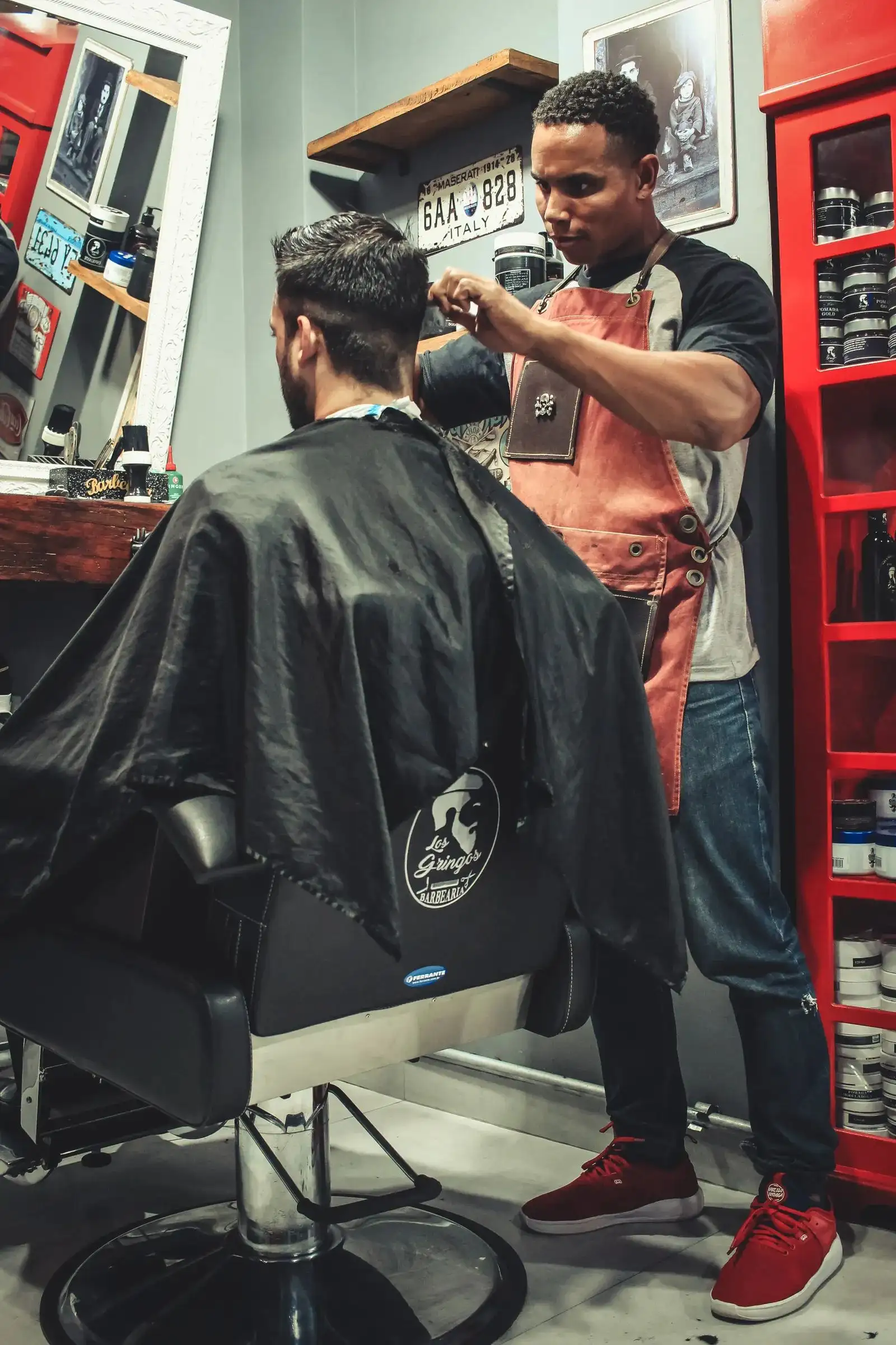 A barber mid-cut in a red-accented shop